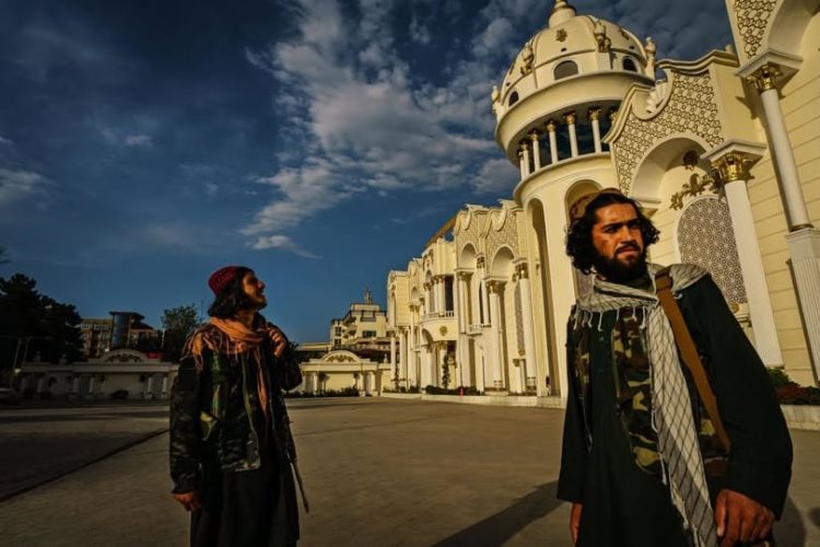Taliban fighters patrol outside an ornate government building in Afghanistan, symbolizing the enforcement of restrictive policies that have shuttered women's businesses and eliminated their economic independence. (Photo Credit: Social Media)
