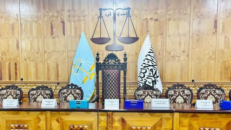 A Taliban courtroom in Afghanistan displays the scales of justice alongside official flags, symbolizing the group's claim to legal authority through its penal codes, which critics argue serve as instruments of repression rather than justice. (Photo Credit: Pajhwok)