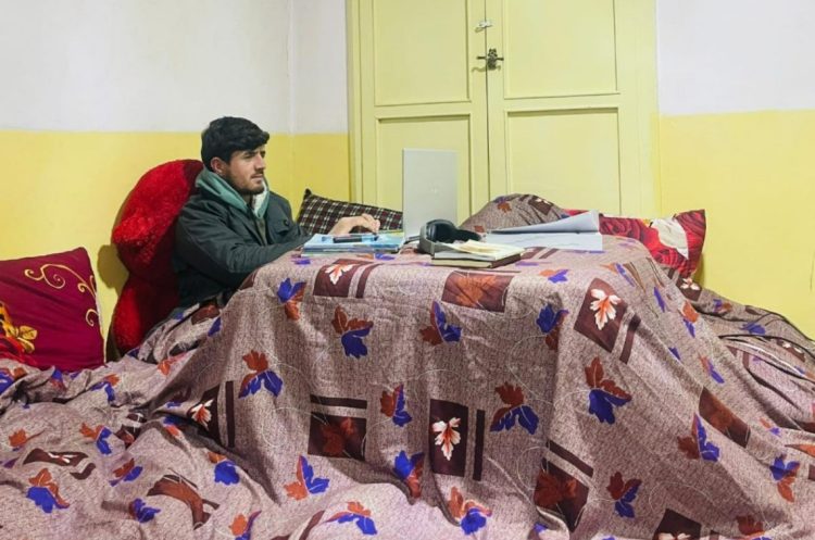 A resident studies beside a sandali, using the traditional heater to stay warm during winter nights amid economic hardship. (Photo Credit: Exclusive)
