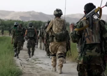 Afghan special forces soldiers patrol in formation through rural terrain. These elite units, known as the "Triples," were trained by and fought alongside British forces before being largely denied resettlement in the UK following the Taliban takeover. Photo Credit: Getty Images