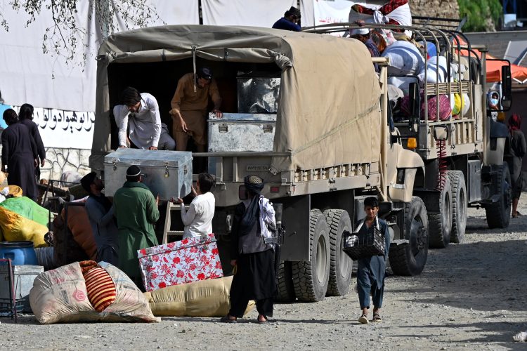 Cargo trucks with migrants loading their belongings, including those likely with U.S. resettlement cases, returning to Afghanistan. Photo Credit: AFP)
