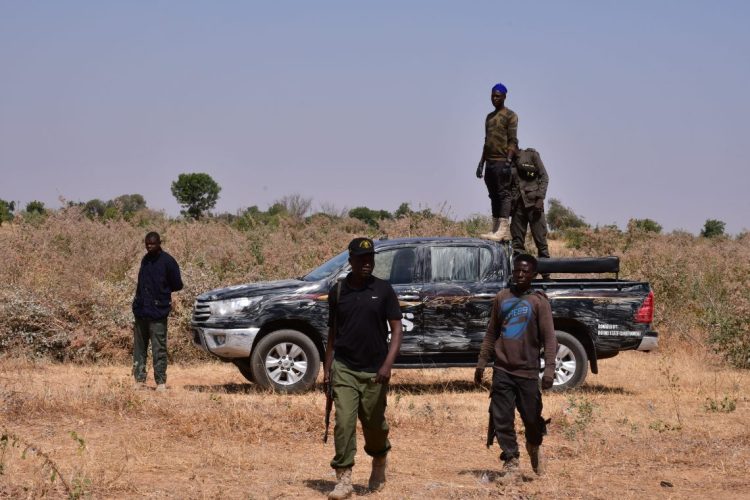 Security personnel stand guard in a dry, open terrain in northwestern Nigeria, amid rising insecurity from armed bandit groups carrying out deadly attacks and abductions across the region. (Photo Credit: Audu MARTE / AFP)