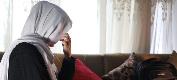 A woman sits in silence, her hand pressed to her face, carrying the quiet weight of loss and uncertainty. (Photo Credit: News un)