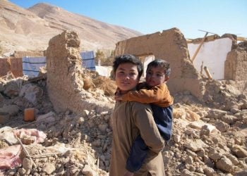 Two children stand amid the ruins of their home in Afghanistan, where millions require urgent humanitarian assistance and access to healthcare and education services. (Photo Credit: https://x.com/TajudeenOyewale)