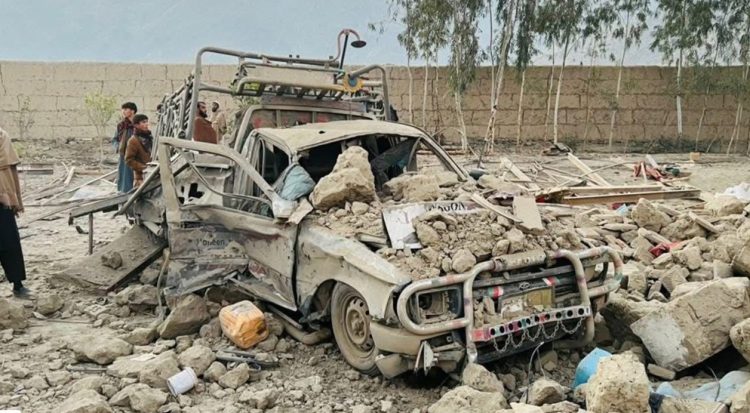 The image shows a vehicle destroyed and mangled amid rubble following the strike. air strike killed 18 members of a single family. Photo Credit: Social Media