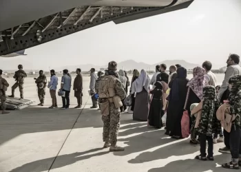 Former Afghan soldier Nazeer Paktiawal among evacuees boarding a U.S. evacuation flight in Kabul. (Photo Credit: AP)