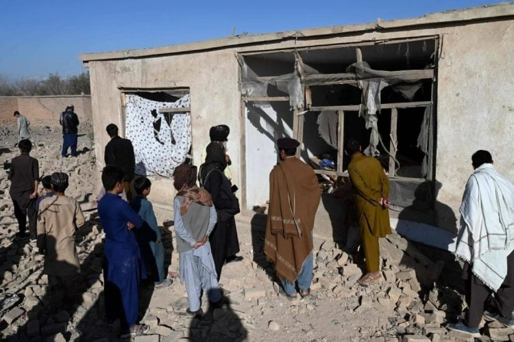 Devastated home in Afghanistan after airstrikes, locals survey the rubble. (Photo Credit: AFP)