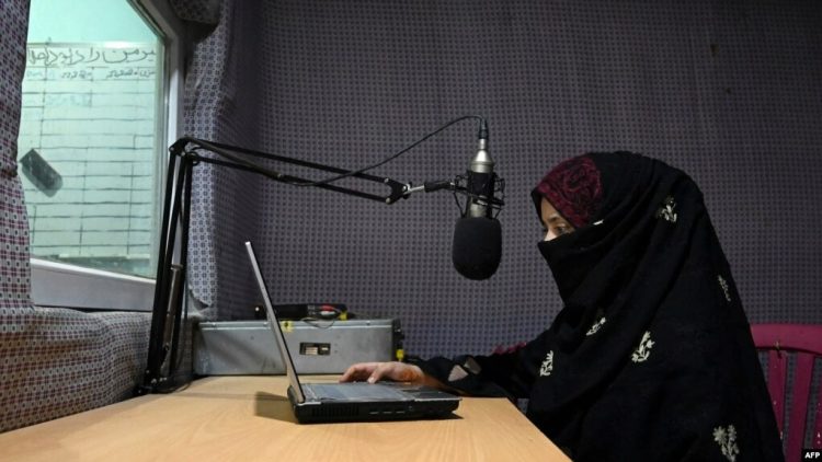 A female journalist works at her desk in a radio studio in Afghanistan, her face veiled in compliance with Taliban restrictions, as she continues her work under growing pressure and censorship. (Photo Credit: AFP)