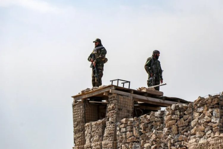 Armed Taliban fighters stand guard atop a fortified post along the Afghan-Pakistani border as tensions escalate between the two sides. (Photo Credit: AFP)