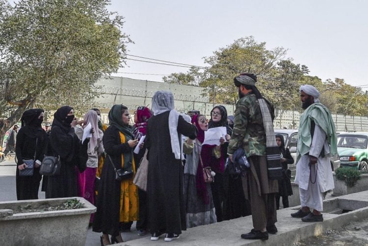 Women in Afghanistan confront Taliban fighters on the street, holding papers in a rare act of public defiance against the regime's sweeping restrictions on their fundamental rights. (Photo Credit: AFP)
