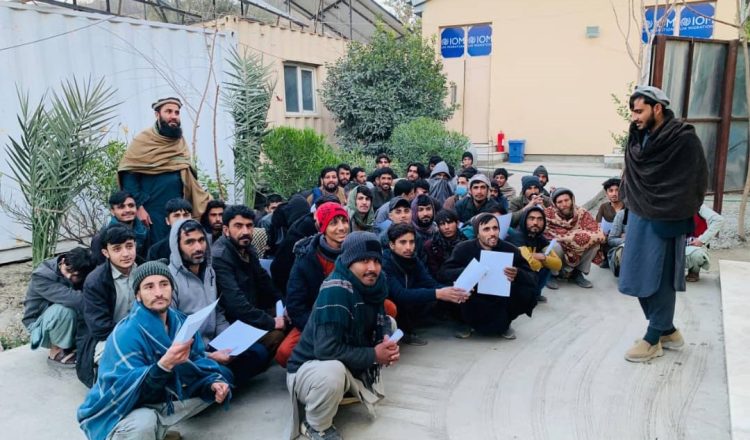Group of Afghan men with papers gathered outdoors (Photo Credit: @MoRRAfg)
