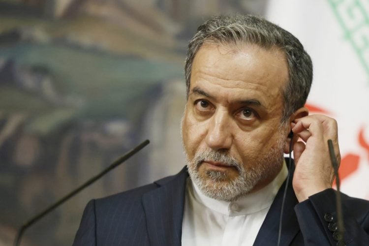 Araghchi adjusts earpiece (Photo Credit: AP)