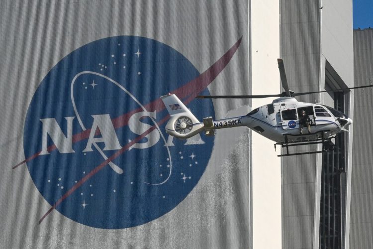 NASA helicopter flies past giant logo at Kennedy Space Center. (Photo Credit: AFP)