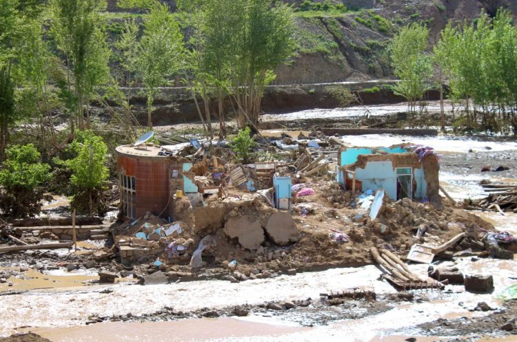 Destroyed homes and debris scattered across a flood-ravaged area as muddy floodwaters surround collapsed structures in Afghanistan. (Photo Credit: REUTERS)