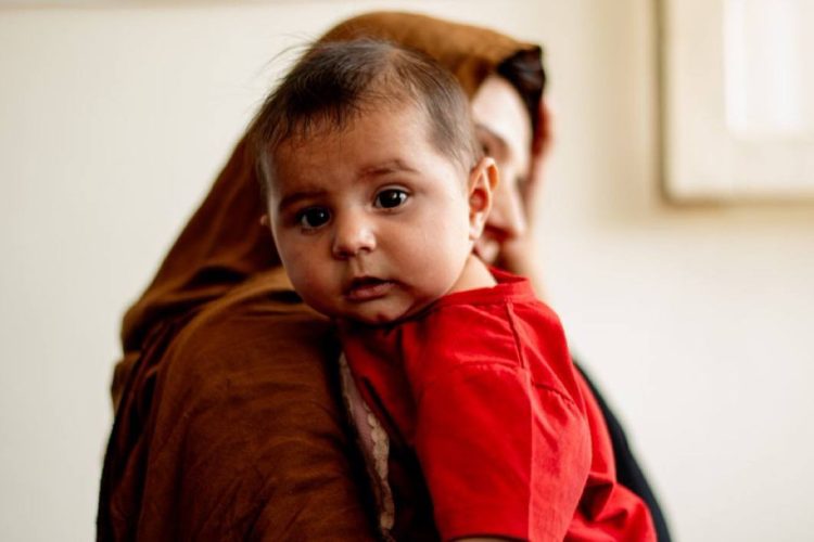 A child in her mother’s arms highlighting hunger and malnutrition risks in Afghanistan. Photo Credit: WFP