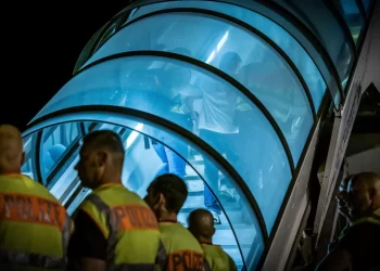 Police escort Afghan deportees on airport stairs (Photo Credit: DPA)