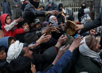 Residents of Afghanistan stretch out their hands to receive bread during a food distribution in Kabul, reflecting the deepening economic crisis gripping the country. (Photo Credit: Reuters)