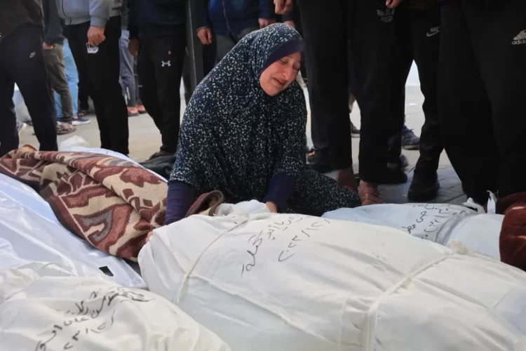 A Palestinian woman weeps over the shrouded bodies of her loved ones killed in Israeli strikes on Gaza, as the war's death toll surpasses 72,000. (Photo Credit: AFP)