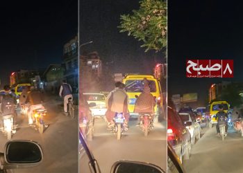 Motorcycles, cars, and a public transport vehicle navigate heavy nighttime traffic congestion on a Kabul street, reflecting the city's growing urban transport crisis. (Photo credit: 8am.media)