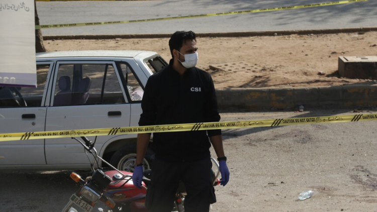CSI investigator in protective gear examines the site of a suicide vehicle attack near a military checkpoint in South Waziristan, Pakistan. (Photo credit: Anadolu)