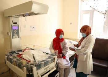 Two doctors stand inside a hospital ward in Afghanistan amid concerns over rising maternal mortality rates. (Photo credit: WHO)