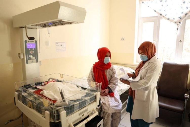 Two doctors stand inside a hospital ward in Afghanistan amid concerns over rising maternal mortality rates. (Photo credit: WHO)