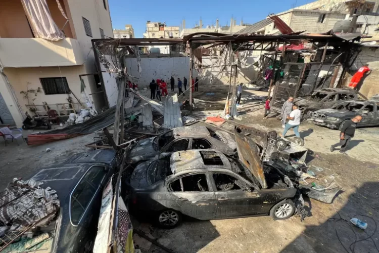 A scene of destruction in Lebanon, showing burned-out vehicles and damage in the aftermath of recent clashes.