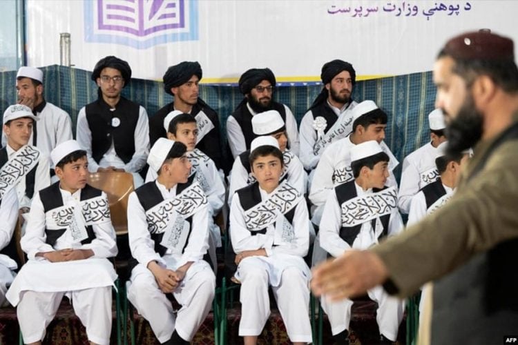 Students attend a public school ceremony under a banner of the Taliban-run caretaker Ministry of Education in Afghanistan. (Photo Credit: AFP)