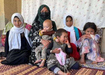 A woman and children in Afghanistan sit together in a modest home, reflecting the humanitarian crisis faced by millions across the country. (Photo credit: WFP)