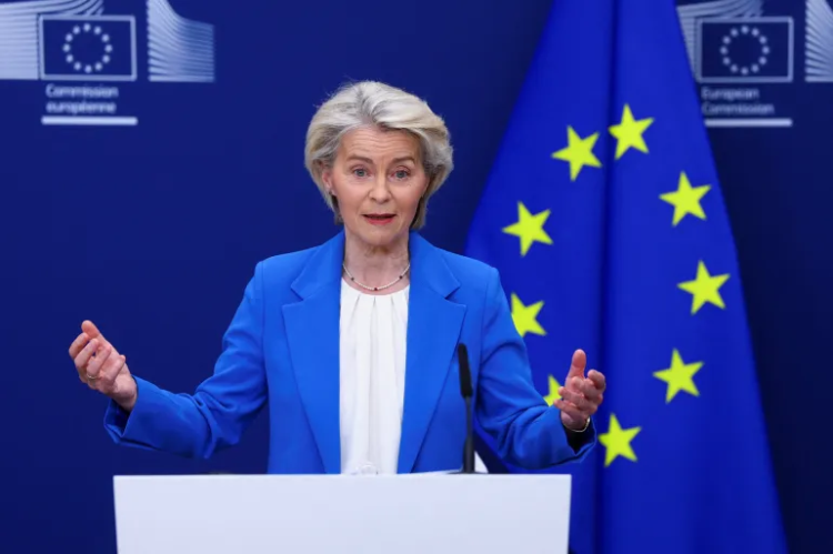 European Commission President Ursula von der Leyen speaks at a podium during an official briefing, addressing Iran sanctions and EU policy conditions, while standing behind a tribune. (Photo credit: Reuters)