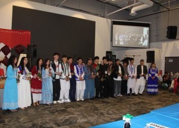 Participants in traditional Hazara attire line up on stage during the Hazara Culture Day ceremony held in Calgary, Canada. (Photo Credit: Exclusive)