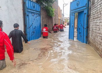 Red Crescent relief workers wade through floodwaters in a residential area to reach families displaced by recent flooding in Afghanistan. (Photo credit: @ECHO_Asia)