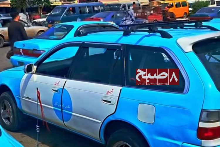 A blue city taxi sits in heavy traffic in Kabul, where drivers say rising taxes and quarterly payments to the Taliban are squeezing their incomes. (Photo credit: 8am.media)