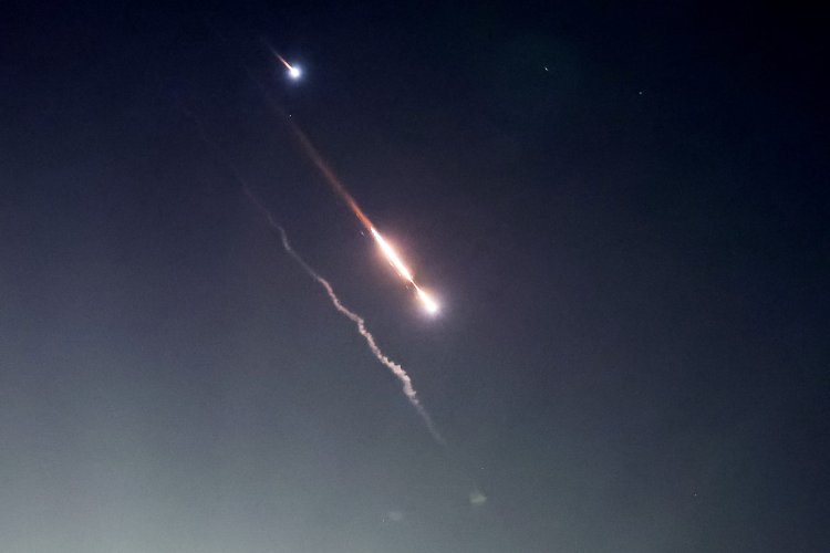 Missiles streak across the night sky, leaving trails of fire and smoke in a tense and dramatic scene. (Photo: Reuters)