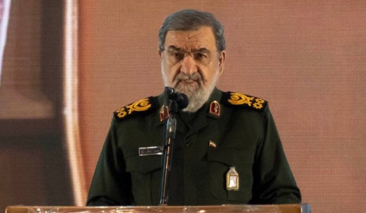 Mohsen Rezaei, military advisor to Iran's Supreme Leader, speaks at a podium in military uniform. (Photo Credit: Al Jazeera)