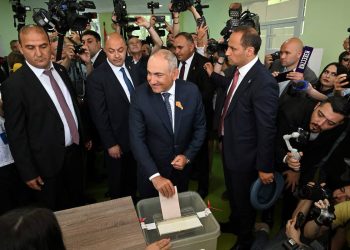 Armenian Prime Minister Nikol Pashinyan casts his vote in the country’s parliamentary election as journalists and photographers cover the event. (Photo credit: REUTERS)