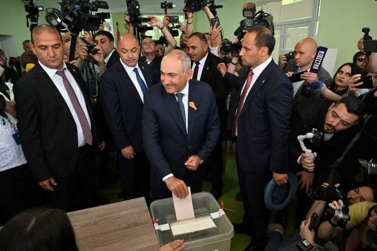 Armenian Prime Minister Nikol Pashinyan casts his vote in the country’s parliamentary election as journalists and photographers cover the event. (Photo credit: REUTERS)