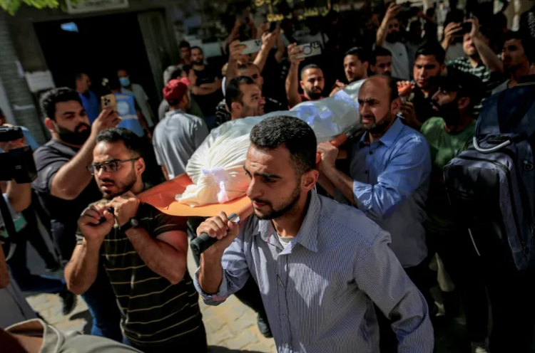 A group of people carrying a body for burial, reflecting the human toll of the ongoing conflict in Gaza. (Photo credit: Saeed Jaras/AA)