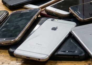 A pile of confiscated smartphones rests on a wooden surface, reflecting growing restrictions on digital access in Afghanistan's universities. (Photo credit: Pexels)
