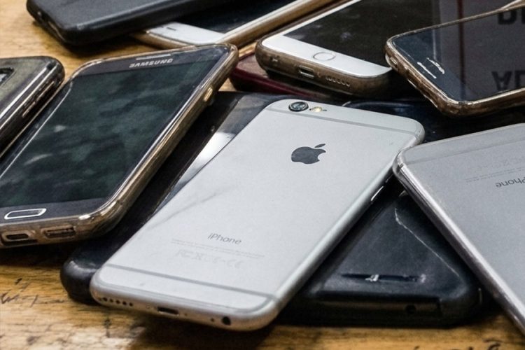 A pile of confiscated smartphones rests on a wooden surface, reflecting growing restrictions on digital access in Afghanistan's universities. (Photo credit: Pexels)