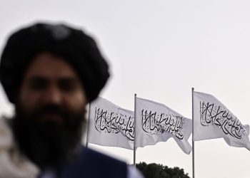 A Talib stands in front of Taliban flags flying in Kabul as the group faces international scrutiny over its human rights record and a controversial EU invitation to Brussels. (Photo credit: AFP)