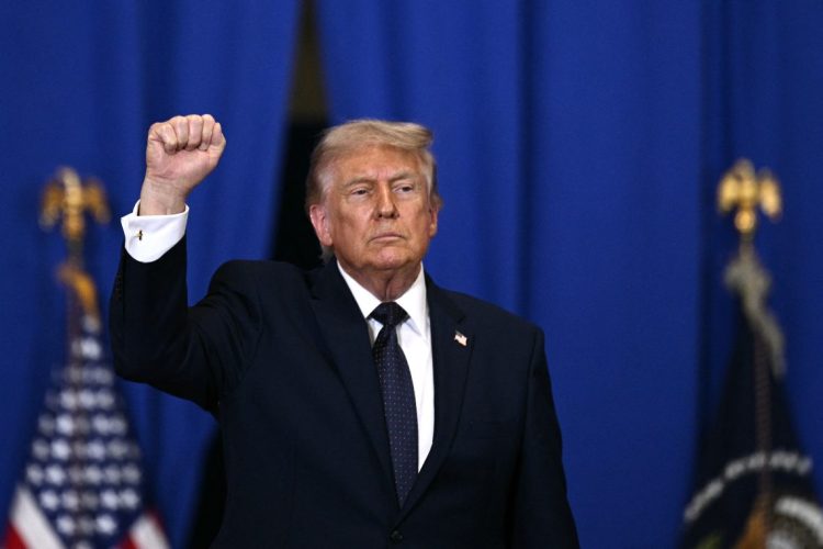 U.S. President Donald Trump raises his fist during a speech, days after claiming Israel would not exist without his intervention against Iran. (Photo credit: BRENDAN SMIALOWSKI / AFP)