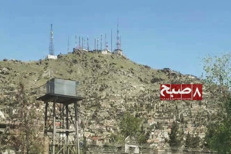 Telecommunication towers stand on a hilltop overlooking a residential neighborhood in Kabul, where residents complain of costly and low-quality internet services. (Photo credit: 8am.media)