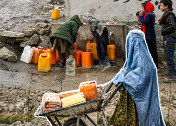 Residents fill jerrycans at a public tap and haul water home by wheelbarrow in Kabul, as the city faces a deepening water crisis. (Photo credit: AFP)