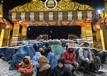 People wait outside a lavishly decorated wedding hall entrance in Kabul as economic hardship reshapes the city's wedding business. (Photo credit: AFP)