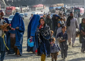 A group of Afghan refugees, including men, women, and children, walk after being returned to Afghanistan (Photo: GETTY IMAGES)