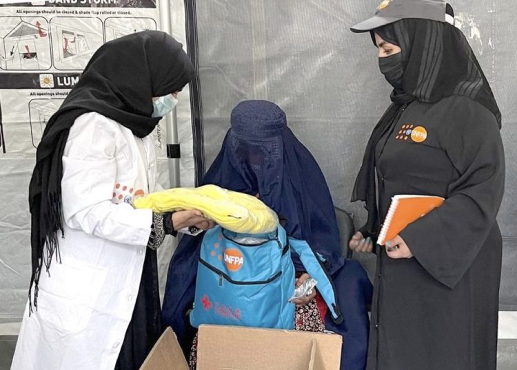 Female health workers provide medical support to a woman affected by floods in Nuristan as part of UNFPA healthcare assistance. (Photo credit: UN)