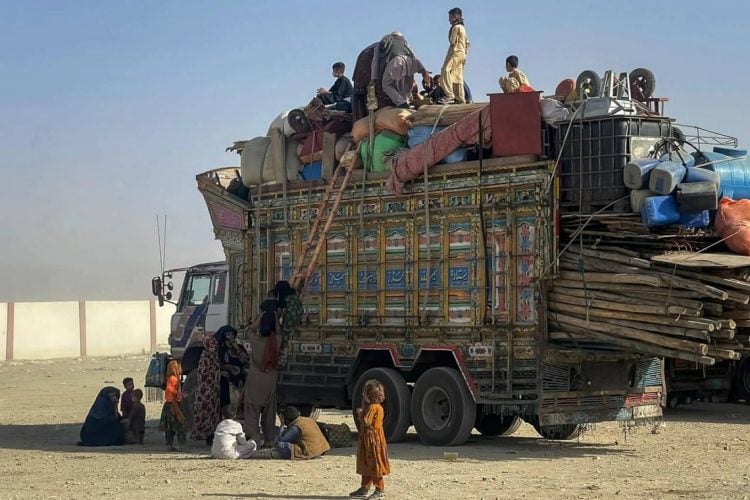 A family of refugees sits in a truck with their belongings during a deportation process from Pakistan to Afghanistan. (Photo credit: AFP via Getty Images)