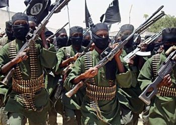 Al-Shabaab fighters raise their weapons during a show of force, as a new UN report says some of the group's members have traveled to Afghanistan. (Photo credit: AP)