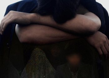 A person sits with arms crossed and head lowered, reflecting the emotional toll of delayed marriage amid economic hardship in Afghanistan. (Photo credit: Pexels + Social Media)